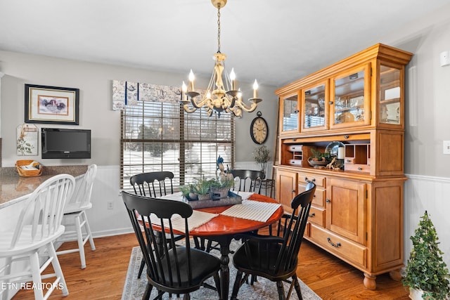 dining area with a notable chandelier and light hardwood / wood-style flooring