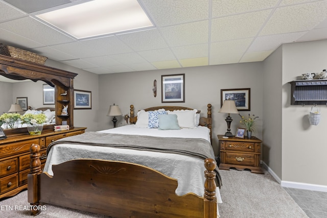 carpeted bedroom with a paneled ceiling