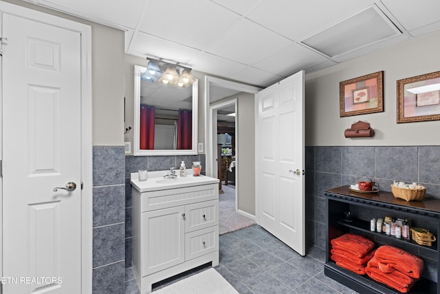 bathroom featuring a paneled ceiling and vanity