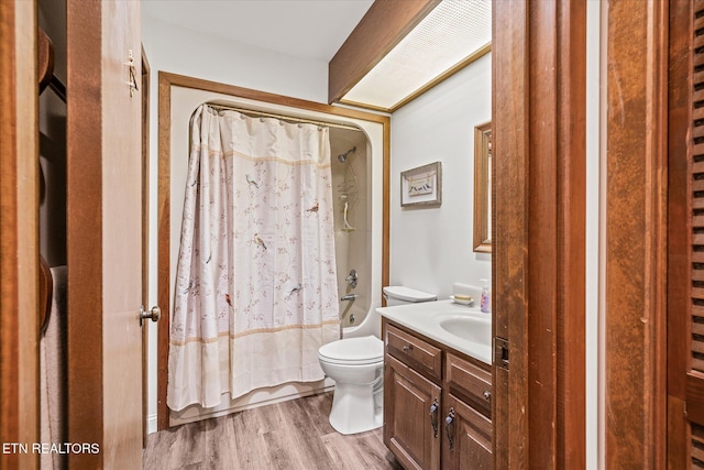 full bathroom with hardwood / wood-style floors, shower / bath combination with curtain, vanity, and toilet