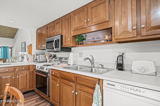 kitchen featuring appliances with stainless steel finishes, sink, and hardwood / wood-style flooring