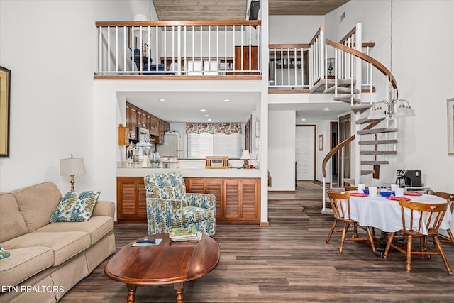 living room featuring a towering ceiling and dark wood-type flooring