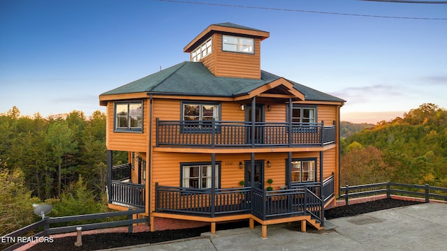 back house at dusk with a balcony