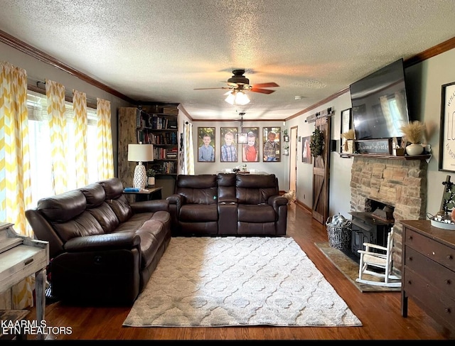 living room with ceiling fan, a wood stove, dark hardwood / wood-style floors, a textured ceiling, and ornamental molding