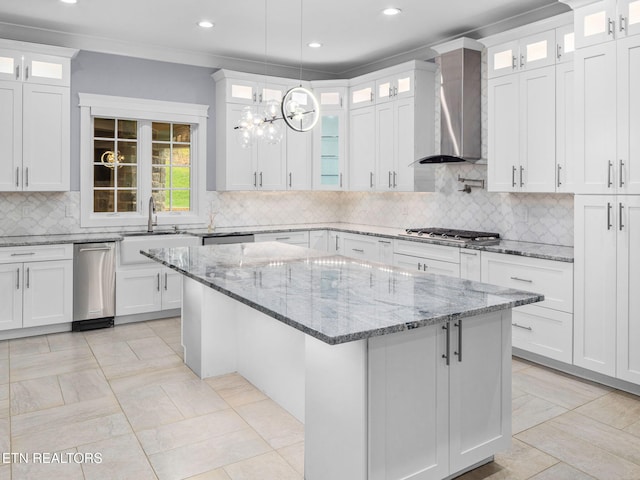 kitchen featuring wall chimney range hood and white cabinetry