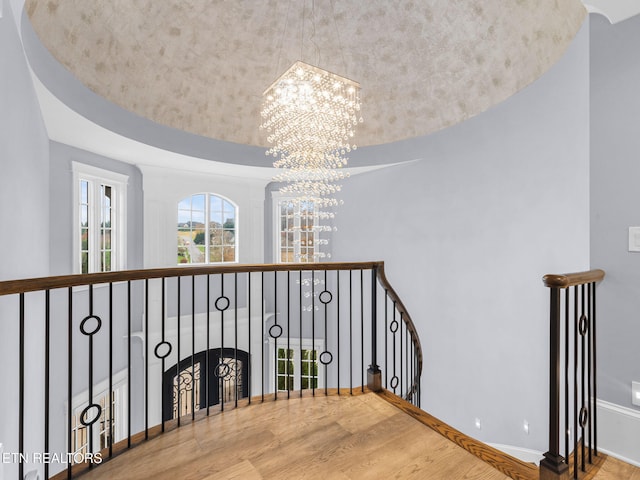 staircase with an inviting chandelier and hardwood / wood-style flooring