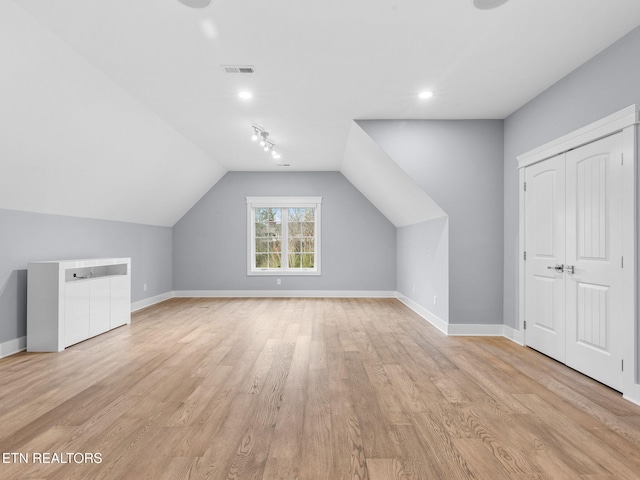 additional living space featuring light hardwood / wood-style floors and lofted ceiling