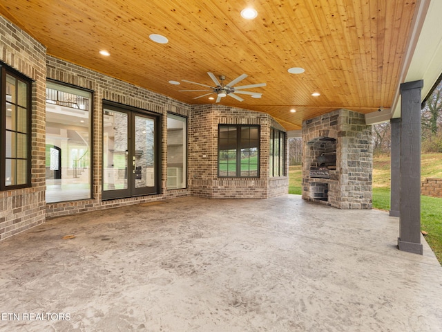 unfurnished living room with brick wall, wooden ceiling, and ceiling fan