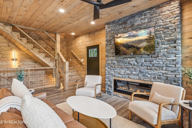 living room with a fireplace, wood walls, wooden ceiling, and hardwood / wood-style floors