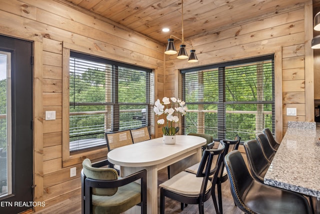 dining room with wooden walls and wood ceiling