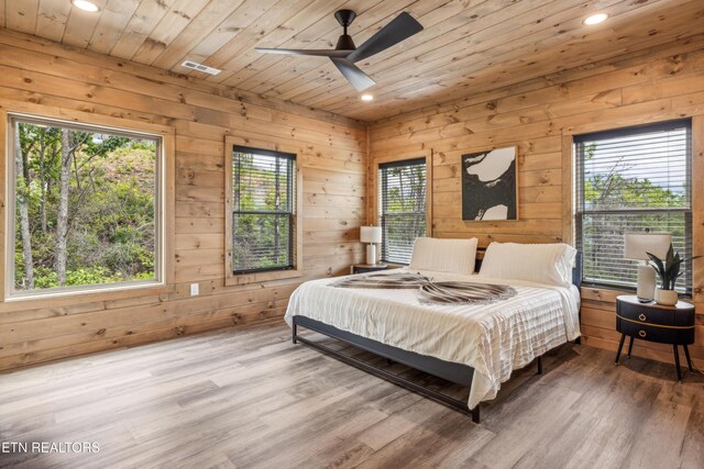 bedroom with ceiling fan, wood ceiling, wooden walls, and hardwood / wood-style flooring