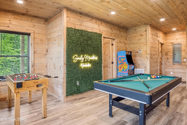 rec room with electric panel, wooden walls, and hardwood / wood-style floors