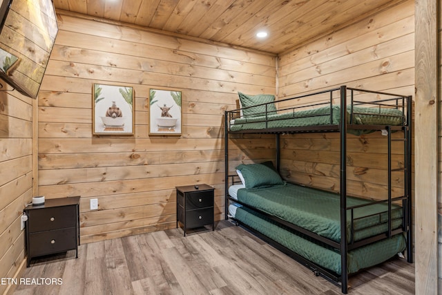 unfurnished bedroom with hardwood / wood-style floors, wooden ceiling, and wood walls