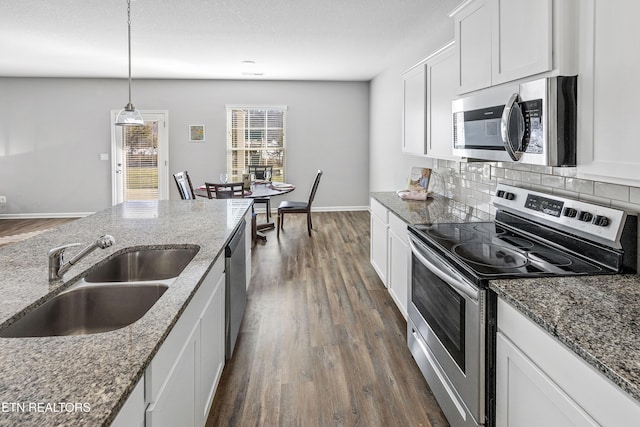 kitchen with sink, stainless steel appliances, light stone countertops, and white cabinetry