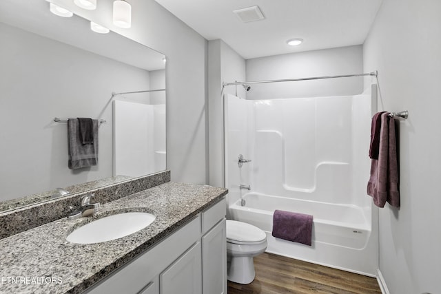 full bathroom featuring hardwood / wood-style flooring, vanity, shower / bathtub combination, and toilet