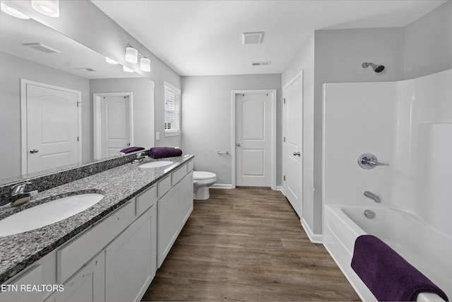 full bathroom with toilet, shower / bath combination, a textured ceiling, vanity, and hardwood / wood-style floors