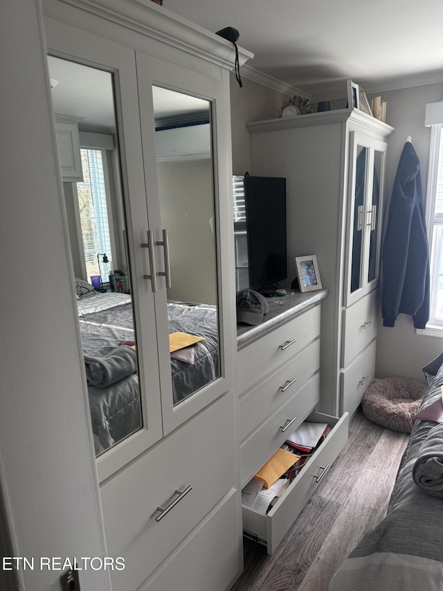 bedroom featuring wood-type flooring and ornamental molding