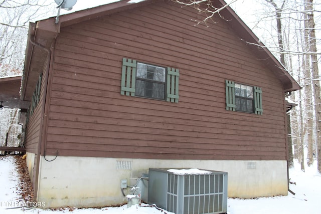 view of snowy exterior featuring central AC unit