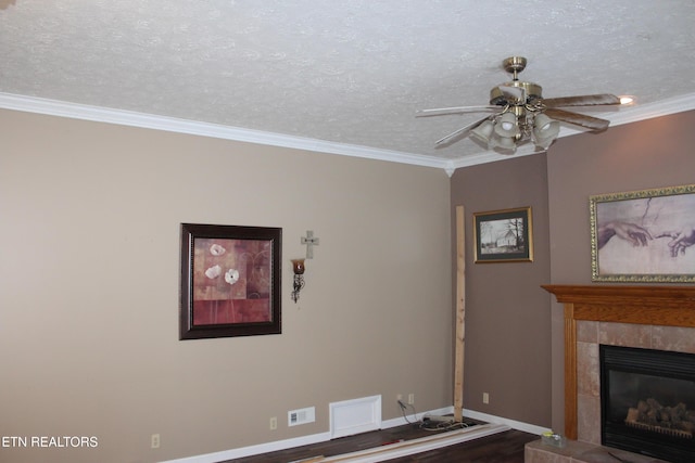 unfurnished living room with a textured ceiling, ceiling fan, crown molding, and a fireplace