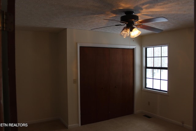 unfurnished bedroom with ceiling fan, a closet, and carpet