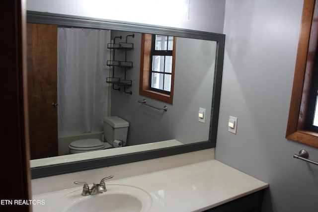 full bathroom with toilet, shower / bath combo with shower curtain, and vanity