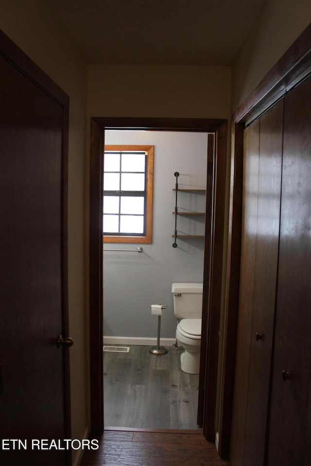 bathroom with toilet and hardwood / wood-style flooring