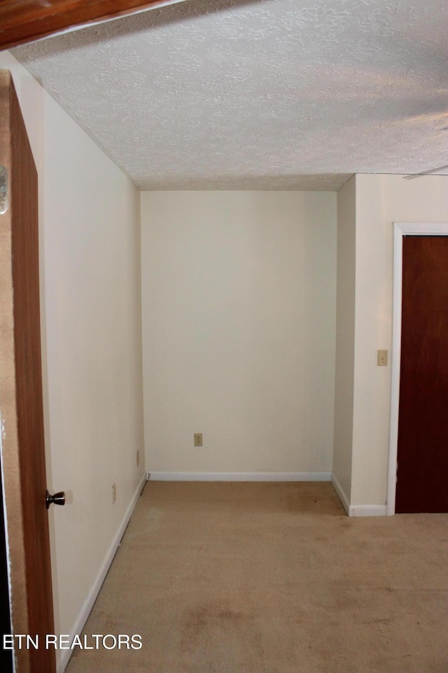 carpeted empty room featuring a textured ceiling