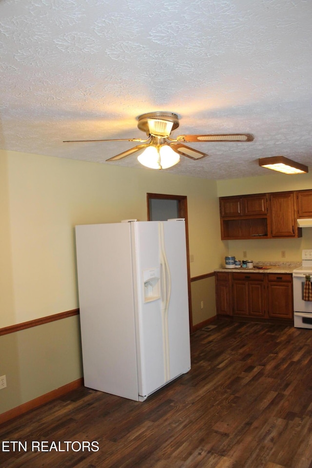 kitchen featuring white appliances, dark wood-type flooring, a textured ceiling, and ceiling fan