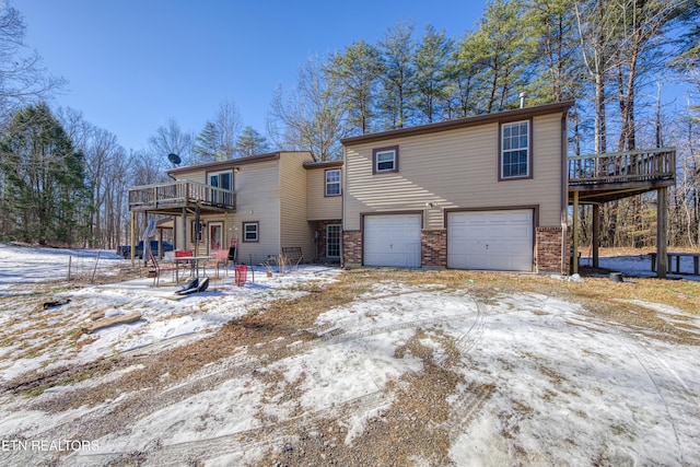 snow covered property with a deck and a garage