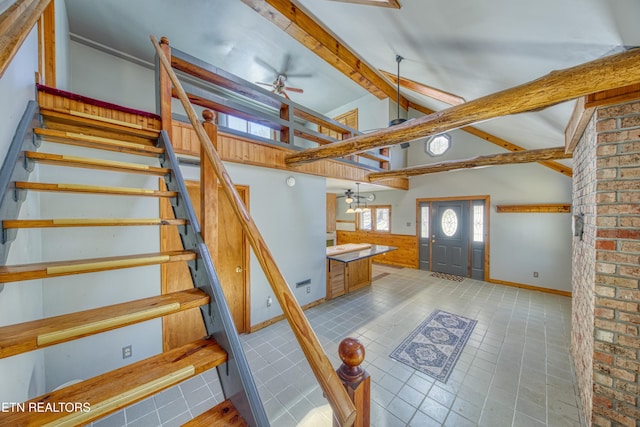 stairs with a chandelier, beam ceiling, and high vaulted ceiling