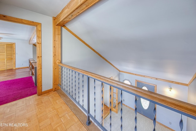 hall with light parquet flooring and vaulted ceiling with beams