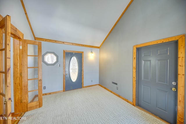 carpeted foyer entrance with ornamental molding and lofted ceiling