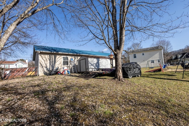 rear view of property featuring a shed and a lawn