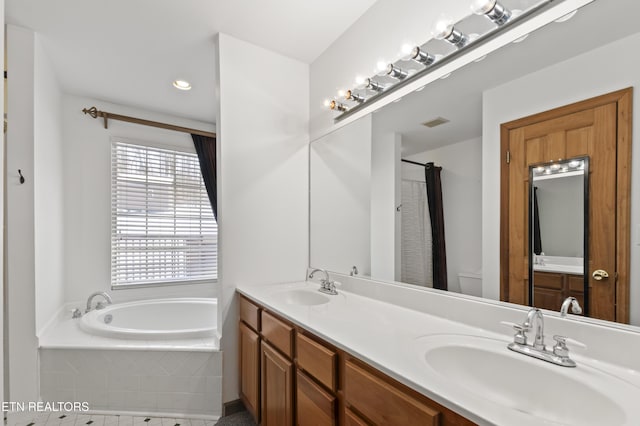 bathroom with tiled bath and vanity