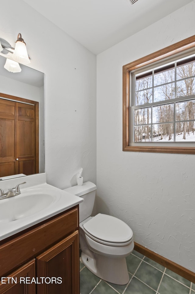 bathroom with toilet, tile patterned flooring, and vanity