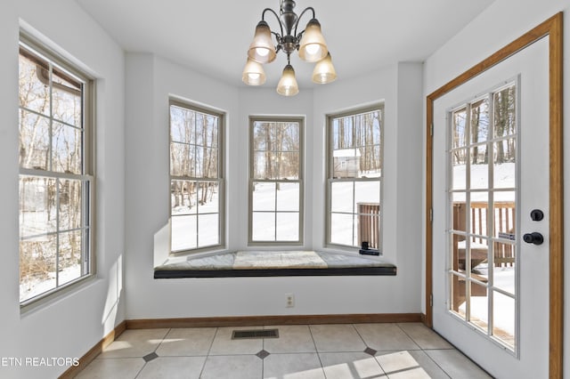 doorway to outside featuring a chandelier and light tile patterned floors