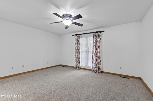 carpeted spare room with ceiling fan