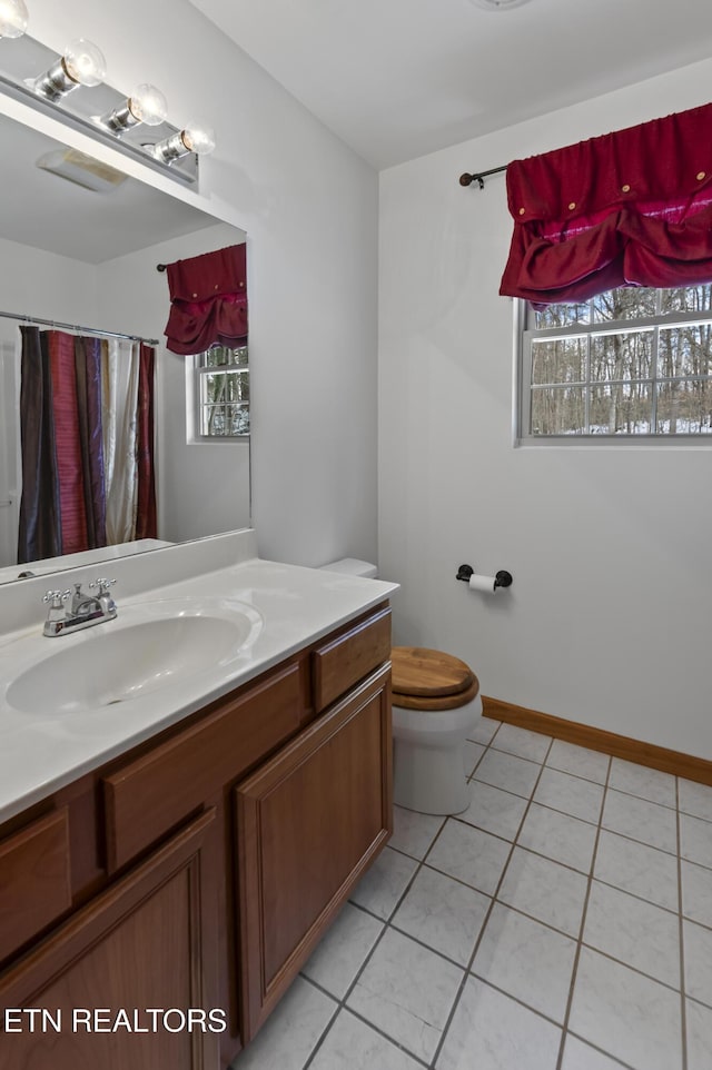 bathroom featuring curtained shower, tile patterned flooring, vanity, and toilet