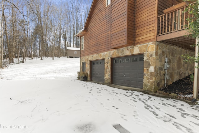 view of snowy exterior featuring a garage