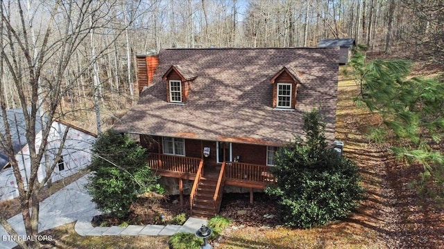 view of front of house with roof with shingles and stairway