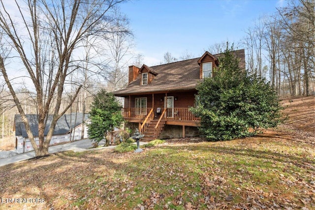 view of front of property with stairs, a porch, and a chimney