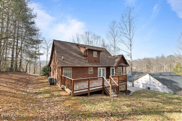 back of property with a shingled roof, central AC, and a wooden deck