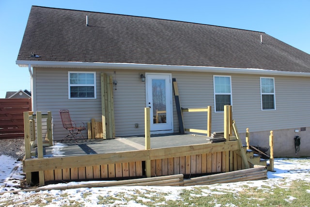 snow covered rear of property with a wooden deck