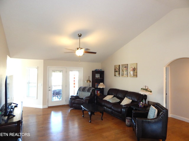 living room with ceiling fan, vaulted ceiling, and dark wood-type flooring