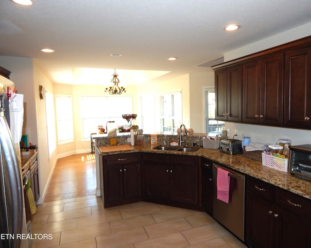 kitchen featuring an inviting chandelier, dishwasher, stone counters, dark brown cabinetry, and sink