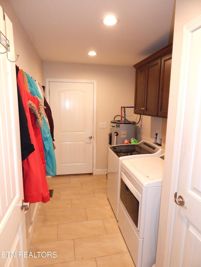 laundry room with cabinets, water heater, washer and dryer, and light hardwood / wood-style flooring