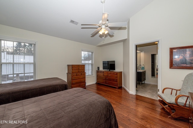 bedroom featuring dark wood-type flooring, ceiling fan, ensuite bathroom, and lofted ceiling