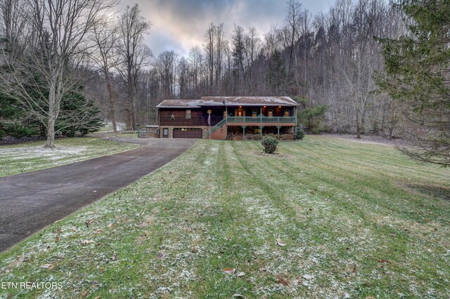 view of front of home featuring a garage, a deck, and a lawn