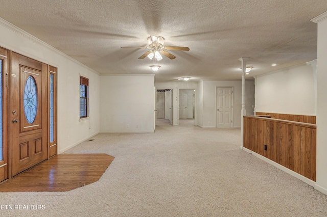 carpeted entryway with ornamental molding, ceiling fan, and a textured ceiling