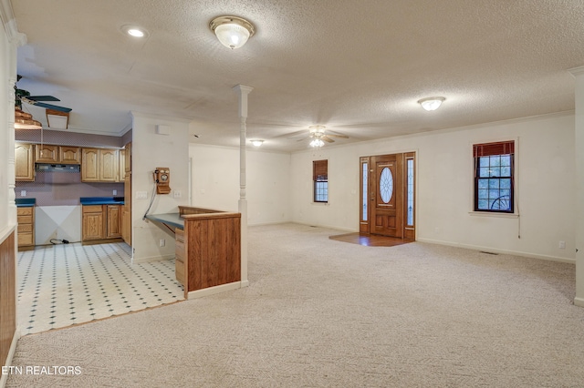 kitchen featuring a textured ceiling, ceiling fan, ventilation hood, crown molding, and light colored carpet